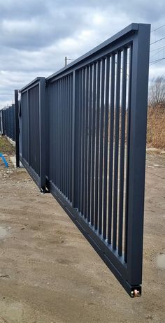 a large metal fence is in the dirt