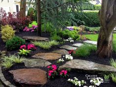 a stone path surrounded by flowers and trees