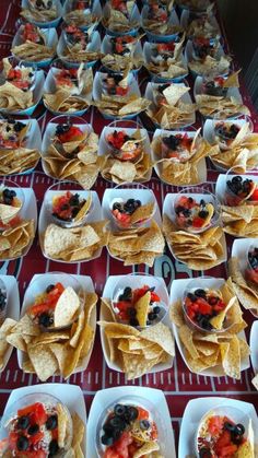 a table topped with lots of plates filled with tacos and fruit salads on tortillas