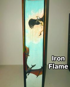 an iron flame holder with a painting of a dragon and a bird on the front