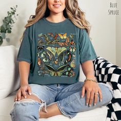 🦋 Step into a world of enchantment and elegance with our Vintage Butterfly & Moth Identification tshirt for women, a masterpiece that seamlessly marries the captivating allure of 26 distinct butterfly and moth species with the timeless comfort of the Comfort Colors brand. Embrace the whimsical charm as you indulge in the delicate beauty of these winged wonders, all elegantly labeled with their respective names. 🍄With a nod to the Cottagecore aesthetic, this t-shirt becomes more than just a garment; it's a piece of art that narrates the story of nature's most exquisite creations. Each butterfly and moth, from the graceful Swallowtail to the mysterious Luna Moth, is thoughtfully depicted in intricate detail. The inclusion of their names adds an educational touch, allowing you to not only w Green Vintage Print Short Sleeve Top, Grunge Style Top With Vintage Print And Relaxed Fit, Casual Green Top With Butterfly Print, Vintage Cotton Tops With Butterfly Print, Butterfly Print Relaxed Fit Crew Neck Top, Butterfly Print Crew Neck Top With Relaxed Fit, Relaxed Fit Butterfly Print Crew Neck Top, Relaxed Cotton Top With Butterfly Print, Grunge Short Sleeve Tops With Custom Print