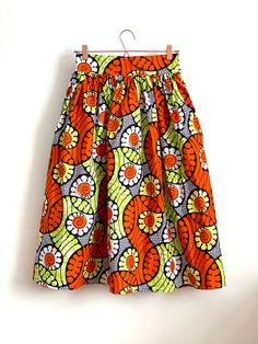 "Lime Green & Orange high waist full gathered skirt. Perfect for casual outfits and special ocasions with pair of trainers or high heels. Elastic at the back of waist.  Two side pockets. Midi length 70 cm + 5 cm waistband. Handmade in UK.  HOW TO CHOOSE A SIZE ?   Using a measuring tape, measure the smallest part of your waist.  SIZE CHART: (CM) XS - W: 66 CM S - W: 70 CM M - W: 74 CM  L - W: 78 CM  XL - W: 82 CM  CARE INSTRUCTIONS: Hand wash only, do not bleach, hang dry, do not tumble dry, press with a cool iron on the reverse side.  Please message me before purchasing so I can check availability. If you wish this skirt in any other fabric, shorter or longer \"send message to seller\" and we can try to make something especially for you." Lime Green And Orange Outfit, High Waist Cotton Gathered Skirt, High Waist Gathered Cotton Skirt, Spring Orange Skirt With Elastic Waistband, Multicolor Voluminous Skirt For Summer, Voluminous Multicolor Skirt For Summer, Fitted Orange Cotton Skirt, Orange Fitted Cotton Skirt, Orange Relaxed Fit Skirt For Summer