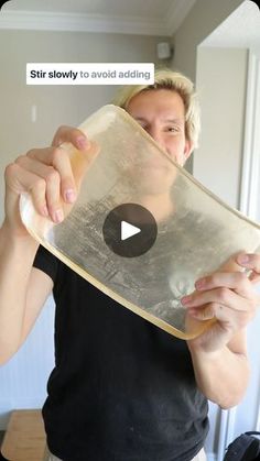 a woman is holding up a large piece of glass in front of her face with the words stir slowly to avoid adding