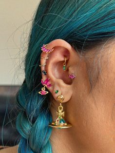 a woman with blue hair wearing ear piercings