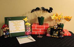 a table topped with vases filled with flowers next to a sign and photo frame