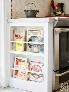 a book shelf with books on top of it in front of an oven and microwave