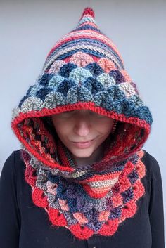 a woman wearing a multicolored crocheted hooded scarf