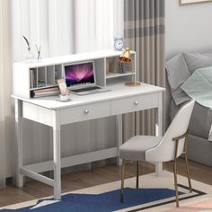 a white desk with a laptop on it and a chair in front of the desk