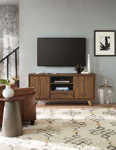 a living room scene with focus on the entertainment center and large screen tv mounted to the wall