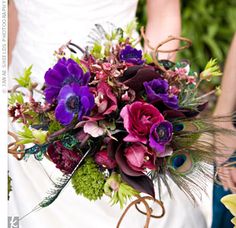 the bride's bouquet is adorned with purple and green flowers, peacock feathers, and greenery