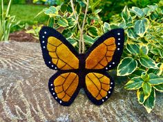 a stuffed butterfly sitting on top of a rock