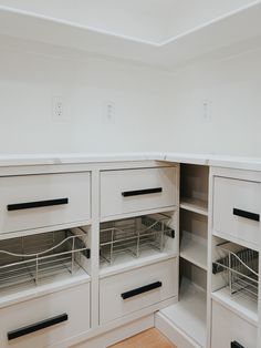 an empty kitchen with white cabinets and drawers