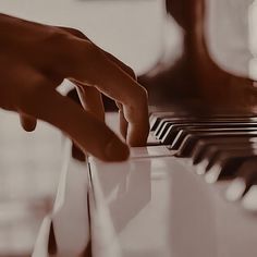 a person's hand on the keys of a piano