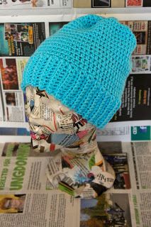 a blue knitted hat sitting on top of a newspaper