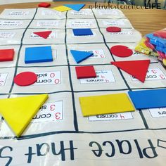 a close up of a board game on a table with pieces of paper and markers