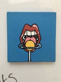 a painting of a woman biting into a lollipop on a blue background with the word kiss written below it