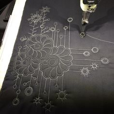 an embroidered table cloth with a glass of wine on it next to the embroidery machine