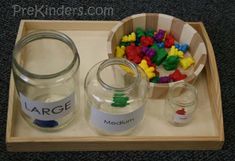 a tray with two jars filled with different colored beads and some sort of magnets