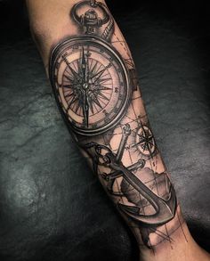 a man's arm with a compass and an anchor on it