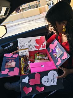 a woman sitting in the back seat of a car filled with valentine's day gifts