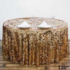 the table is covered with gold sequins and place settings for two people to sit at