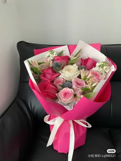 a bouquet of flowers sitting on top of a black couch