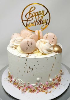 a birthday cake with white frosting and gold sprinkles