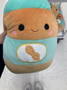 a person holding a stuffed animal with a cookie on it's back