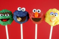 four sesame street lollipops with faces on them