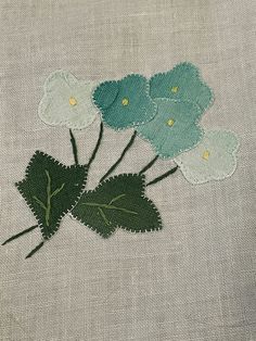 embroidered flowers on linen with green leaves