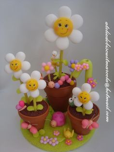 there is a cake that looks like it has flowers in the pot and balloons on top