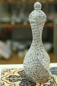 a blue and white vase sitting on top of a table next to a mouse pad