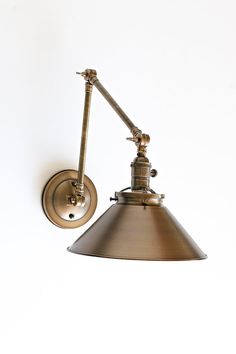 an industrial style wall light with a metal shade on the side and a white background