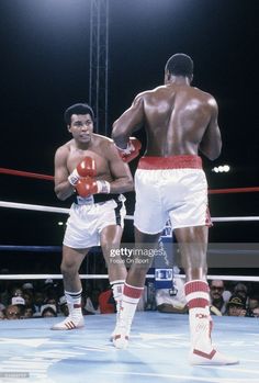 two men standing next to each other in a boxing ring