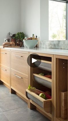 a kitchen filled with lots of wooden cabinets and counter top space next to a window