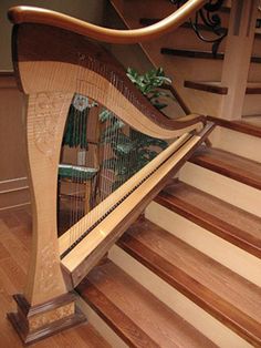 a large wooden harp sitting on top of a set of stairs next to a potted plant