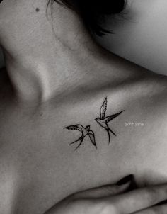 a woman's chest with a bird tattoo on it