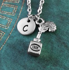 the initial charm is attached to a silver necklace with a letter and an angel on it