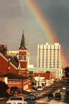 a rainbow in the sky over a city street