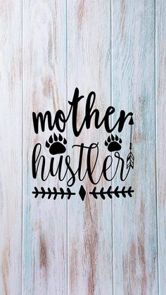 the word mother hustler written in black ink on a white wood background