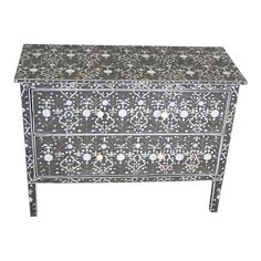 a black and white chest with flowers on the front, inlayed to it's sides