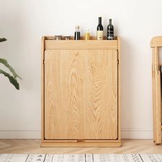 a wooden cabinet sitting next to a potted plant on top of a white rug