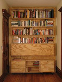 a bookshelf filled with lots of books on top of wooden shelves next to a doorway