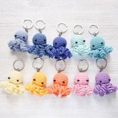 small crocheted octopus keychains are lined up on a white surface,