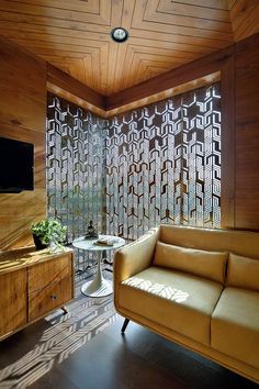 a living room filled with furniture and a flat screen tv on top of a wooden wall