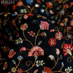 the black fabric has red and blue flowers on it, along with gold trimmings