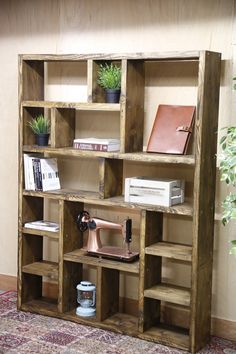 an old bookcase with books and sewing machine on it in front of a potted plant