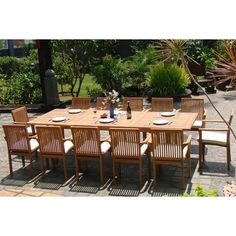 an outdoor dining table with chairs and plates on it