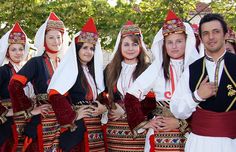 a group of people standing next to each other wearing costumes and head coverings on their heads