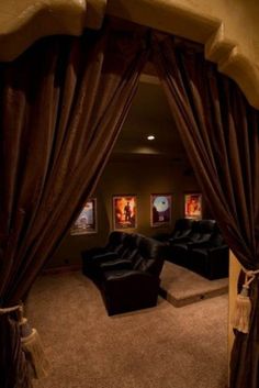 a living room filled with black furniture and curtains